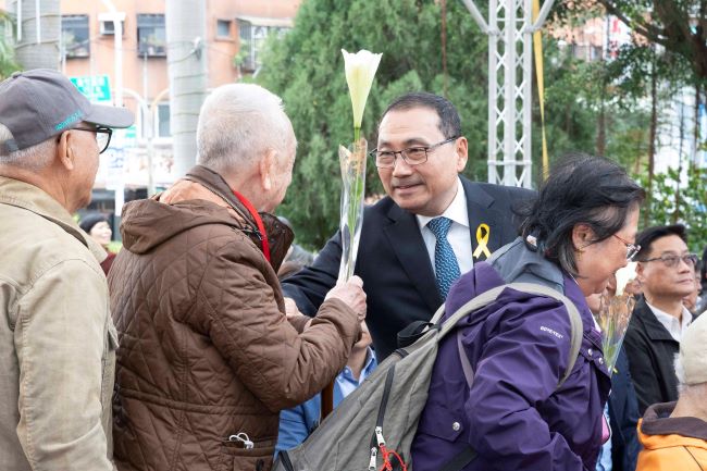 《圖說》侯友宜市長逐一遞送鐵炮百合給受難者家屬獻花，撫慰受難者心靈。〈民政局提供供〉